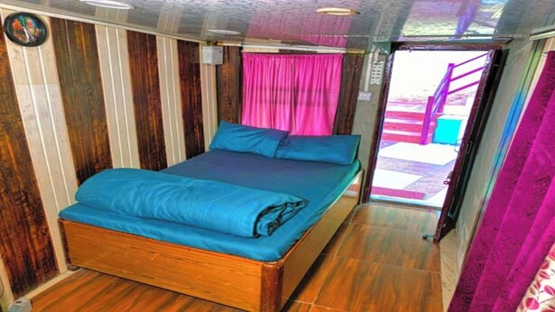 Una habitación con una cama, una cortina y una puerta.