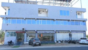 En toetagers bygning med butiksvindue, hvor der står 'BLACK PANTHER' og 'MANDAL ASSOCIATES'.