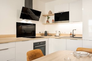 A modern kitchen with a built-in oven, a microwave, and a coffee maker. - Alpine - Modern 2PAX | Near train station & thermal baths | Peaceful (Saint-Gervais-les-Bains)