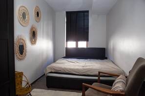 Un dormitori amb llit, finestra i decoracions murals.