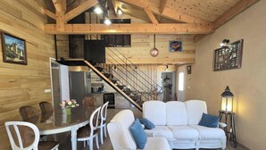 Ein gemütlicher Innenraum mit Essbereich, einer Couch, einer Treppe und einer Küche.