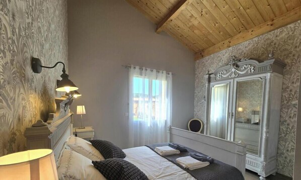 A bedroom with a bed, bedside lamps, a mirror, and a wardrobe. - House with AC, pets welcome - 6 guests (Lalinde)