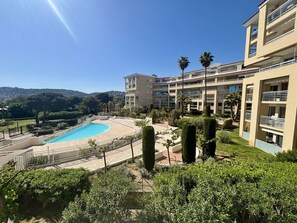 A hotel with a swimming pool, surrounded by greenery and a view of the hills. - Bright apartment, park view - 4 guests (Juan les Pins)