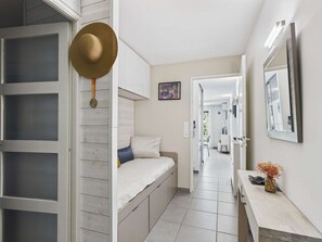 A modern interior with a bunk bed, a vanity with a mirror, and a hallway leading to a dining area. - Apartment with AC and WiFi - 5 guests - In the village center (Le Grau d'Agde)