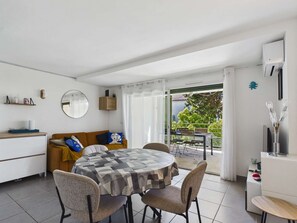 A modern kitchen with a dining area, a sofa, and a view of the outdoors. - Apartment with AC and WiFi - 5 guests - In the village center (Le Grau d'Agde)