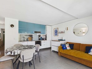 A modern apartment with a kitchen, dining area, and living room. - Apartment with AC and WiFi - 5 guests - In the village center (Le Grau d'Agde)