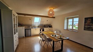 Una cocina con comedor, ventilador de techo y ventana con un cartel.