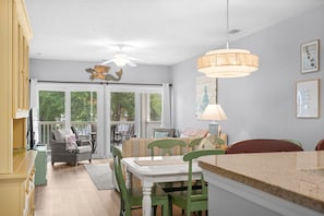 Ein Essbereich mit Tisch, Stühlen und Deckenventilator.