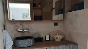 A bathroom with a round sink, a mirror above it, and a towel hanging on the wall. - La Corsica (Sillans-la-Cascade)