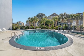 A swimming pool with a 8 ft depth marker, surrounded by palm trees and a fence. - Seascape Cove at Holiday Towers 605 elevator/pool (Myrtle Beach)