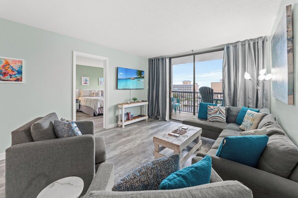 Comfy living room area with large TV and balcony access - Seascape Cove at Holiday Towers 605 elevator/pool (Myrtle Beach)