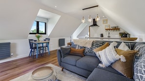 A loft-style living space with a dining area, a sofa, and a kitchen. - Ferny Retreat -  Romantic barn conversion, Hay-On-Wye (Bromyard)