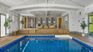 A swimming pool with a tiled deck, a seating area with chairs, and a view of the outdoors. - Ferny Retreat -  Romantic barn conversion, Hay-On-Wye (Bromyard)