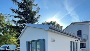En modern byggnad med ett platt tak, stora fönster och en skylt som visar att det är en bostadsbyggnad.