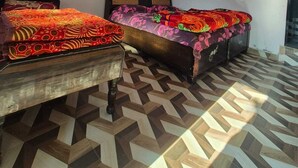 Una habitación con dos camas, un ventilador de techo y un suelo estampado.