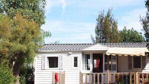 A mobile home with a front porch, a small deck, and a mailbox. - Family Escape Steps From the Sea (Hyères)