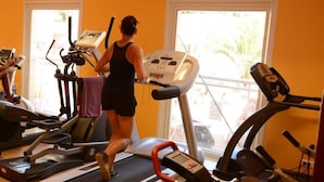 A gym with treadmills, a stationary bike, and a rowing machine. - Family Escape Steps From the Sea (Hyères)