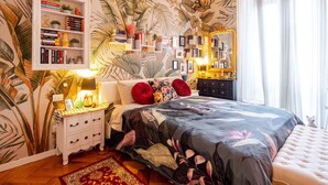 A bedroom with a large bed, a nightstand, a dresser, a bookshelf, and a mirror. - Tropical Chic Flat Near the Centre, 15 minutes to Duomo (Milano)