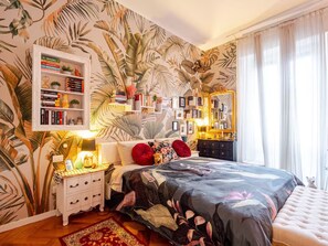 A bedroom with a large bed, a nightstand, a dresser, a bookshelf, and a mirror. - Tropical Chic Flat Near the Centre, 15 minutes to Duomo (Milano)