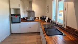 Una cocina moderna con horno integrado, cafetera y ventana con vistas.