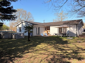 A two-story house with a patio, a swimming pool, and a small garden.