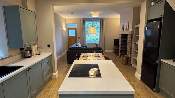 Een moderne keuken met een centraal eiland, inbouwapparatuur en een eetgedeelte met uitzicht.