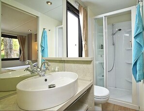 A bathroom with a large sink, a toilet, and a glass-enclosed shower. - Adriatic Family Stay by the Sea (Brtonigla)