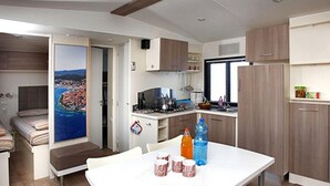 Una cucina compatta con tavolo da pranzo, forno a microonde e frigorifero.