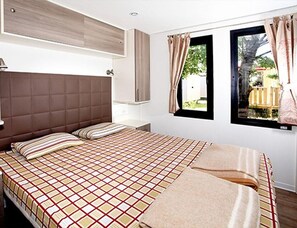 A bedroom with a large bed, a headboard, a window with curtains, and a view of the outside. - Adriatic Family Stay by the Sea (Brtonigla)