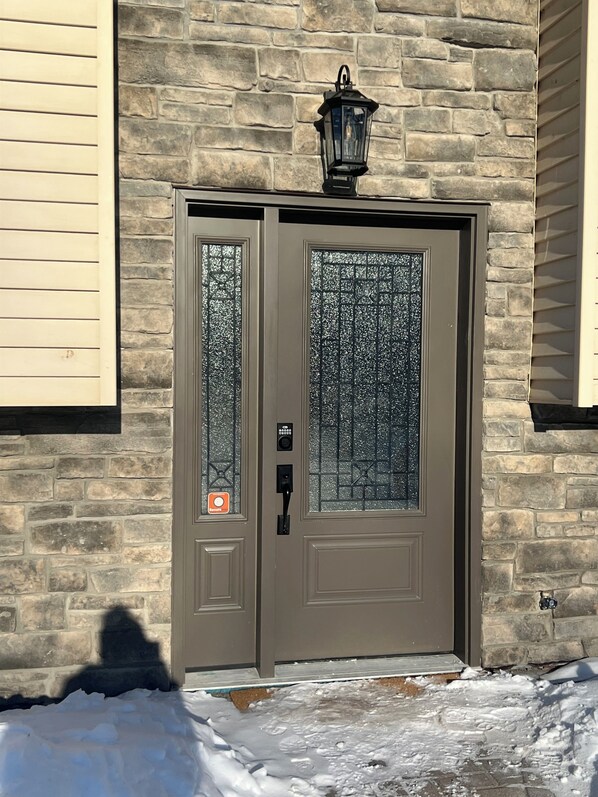 A double door with a frosted glass panel, a doorbell, and a mailbox.