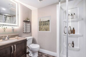 Une salle de bain avec des toilettes, un lavabo et une douche.