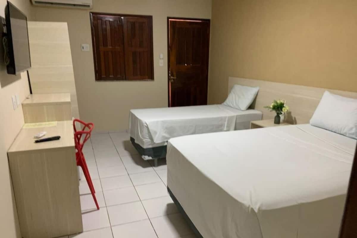 A room with two beds, a desk, and a chair.