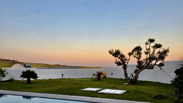 Una piscina con una vista despejada del cielo y un árbol al fondo.