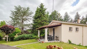 A single-story house with a covered patio, a small garden, and chickens on the lawn. - Peace 3 bed gîte (Chevanceaux)