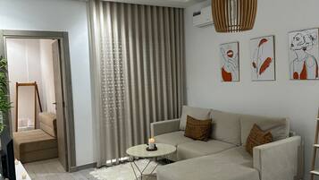 A modern living room with a sectional sofa, a small round coffee table, and a pendant light.