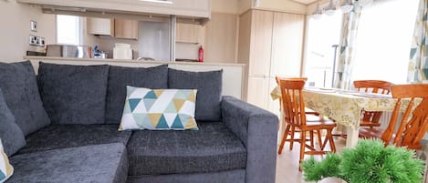 A modern living area with a sofa, a dining table, and chairs.