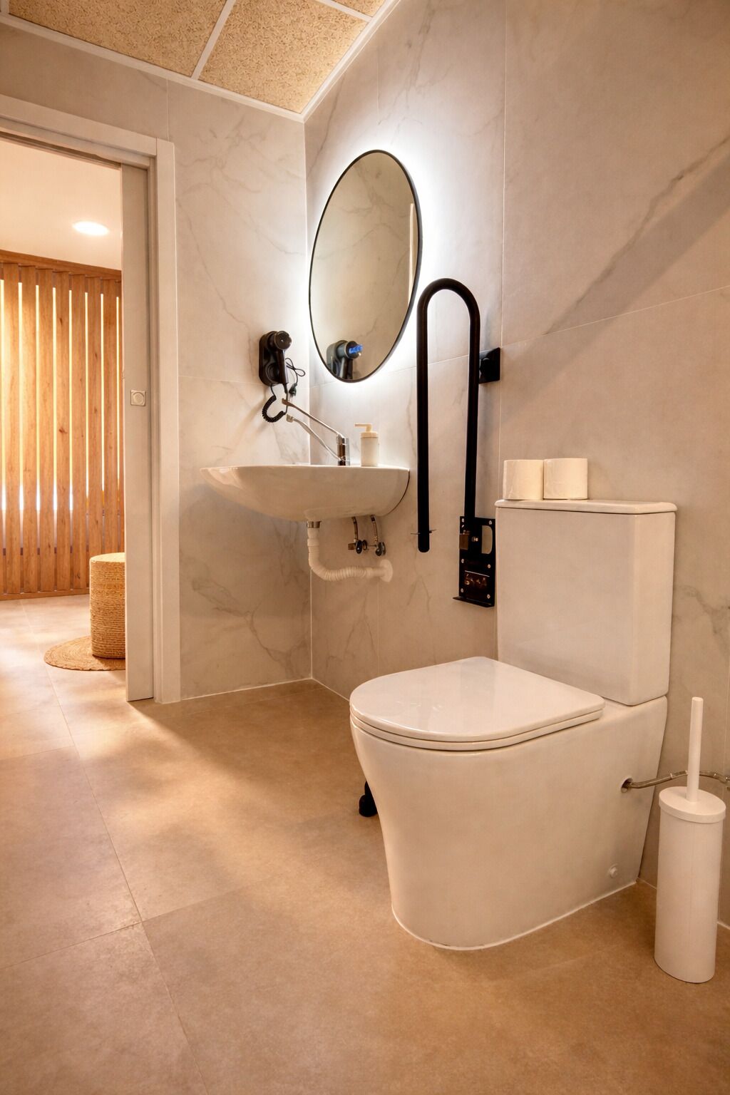 Ein modernes Badezimmer mit einem weißen Waschbecken, einer Toilette und einem Spiegel.