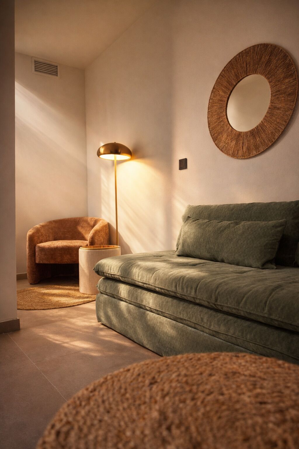 Ein modernes Wohnzimmer mit einer Couch, einer Stehlampe und einem runden Spiegel an der Wand.