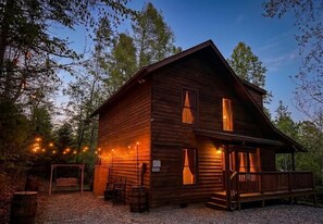 Eine rustikale Holzhütte mit Veranda, Lichterkette und Schaukel.