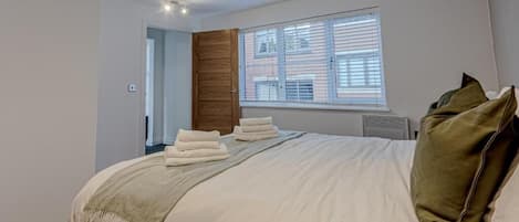 Tabla de planchar con plancha, internet y ropa de cama