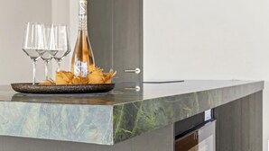 A marble countertop with a bottle of champagne, two glasses, and a plate of snacks. - NEW 4BR Villa With 2 Pools at Blue Bay (Sint Michiel)