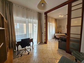 A spacious room with a desk, chair, and a dining area with a table and chairs. - Cozy apartment in Talenti - Well connected and quiet" (Roma)