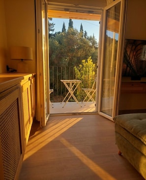 Ein Zimmer mit einer Schiebetür und einem Balkon mit Tisch und Stühlen.