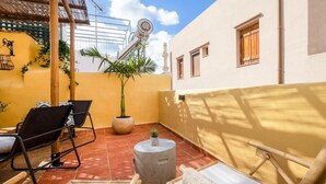 A rooftop terrace with a seating area, a potted plant, and a water tank. - Maisonette in center of Chania with roofgarden! (Chania)