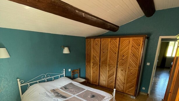 Une chambre à coucher avec un lit, une armoire et une lampe.