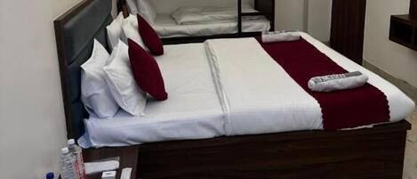 Dormitorio con literas, ventilador de techo, una mesita con una bandeja de desayuno y aire acondicionado instalado en la pared.