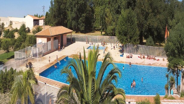 A swimming pool surrounded by a fence, with people swimming and sunbathing. - Spacious Beachside Apartment for 6 (Saint-Cyprien)