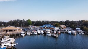 A marina with docked boats, a gas station, and a building with a blue roof. - Reel Em' Inn -3bdr 2.5ba Waterfront Home Located at Pier98 Marina -Pets Welcome (Panama City)