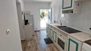 Eine moderne Küche mit Kochinsel, integrierten Geräten und Blick ins Freie.
