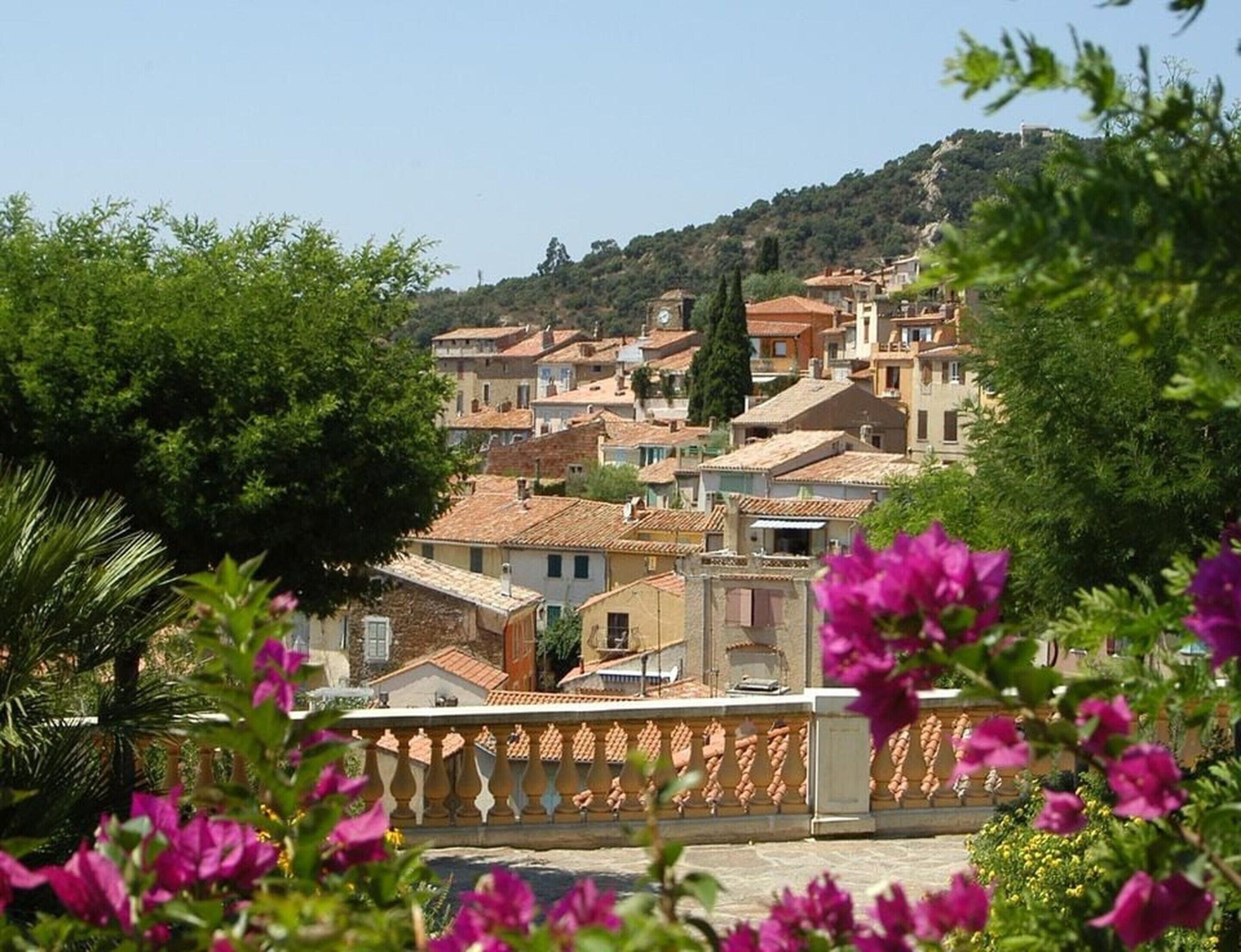 A hillside village with traditional architecture, a prominent church, and lush greenery.